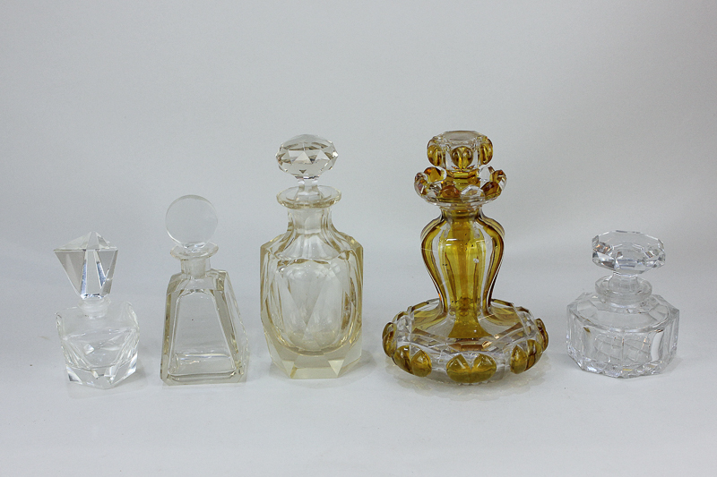 A 19th century cut glass scent bottle with yellow stripes and unusual form, together with four clear