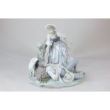 A Lladro porcelain figure group of a sleeping man and a woman going to wake him, next to tree