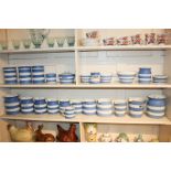 A large collection of blue and white Cornishware pottery including storage jars and jugs