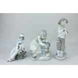 Three Nao porcelain figures of a seated clown with letter, a boy with bird, and a girl with spilt