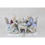 A Continental porcelain figure group of a man and a woman in 18th century dress playing cards,