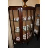 A mahogany demi-lune display cabinet with single door enclosing two glass shelves, 77cm