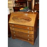 An Edwardian banded mahogany bureau, the drop writing flap with oval inlaid panel enclosing fitted