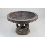 An African carved wooden bowl with decorative border, on pedestal stand, 30cm