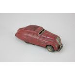 A Schuco clockwork tin plate mechanical toy motor car, Kommando Anno 2000, in red, play worn, no