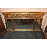 A gilt three-panel over-mantel mirror with cornice panel decorated with scrolling foliage and