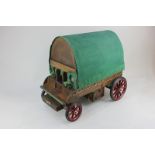 A scratch built model of a gypsy caravan with wooden frame and green canvas hood, approximately 42cm