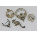 Three Scottish silver Celtic design brooches, a seahorse brooch, a stag's head brooch