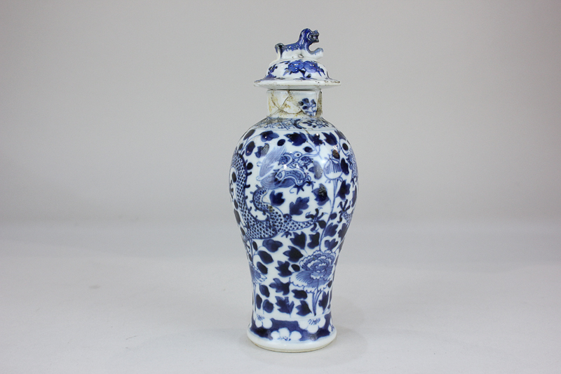 A Chinese porcelain baluster vase and cover decorated in blue and white with dragons amongst flowers