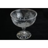 A circular glass pedestal fruit bowl, etched with grapes and vine leaves, 20.5cm high, 20cm