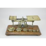 A set of brass postal scales and weights, mounted on wooden plinth, 24cm