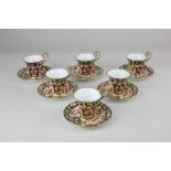 A Royal Crown Derby porcelain coffee set of six cups and saucers in the Imari pattern (one broken