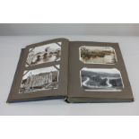 An early 20th century postcard album containing photographic postcards of ships, vehicles and