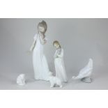 Two Nao porcelain figures of girls, one in a nightdress, the other with a puppy, a pair of Nao polar