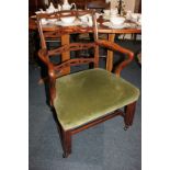 A Chippendale style mahogany carver dining chair with pierced ladder back, curved arms, and green