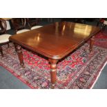 A mahogany extending dining table with one extra leaf, on turned reeded legs and castors, approx.