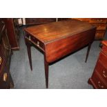 A mahogany Pembroke table with two drop flaps, drawer and opposing dummy drawer, on square tapered