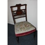 An Edwardian inlaid mahogany nursing chair with pierced urn and scroll decorated back and tapestry