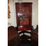 A reproduction mahogany corner cupboard with three shelves enclosed by glazed panel door, 83cm, on a