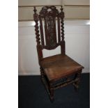 A carved oak hall chair, with foliate pierced back and floral carved hard seat, with barley twist