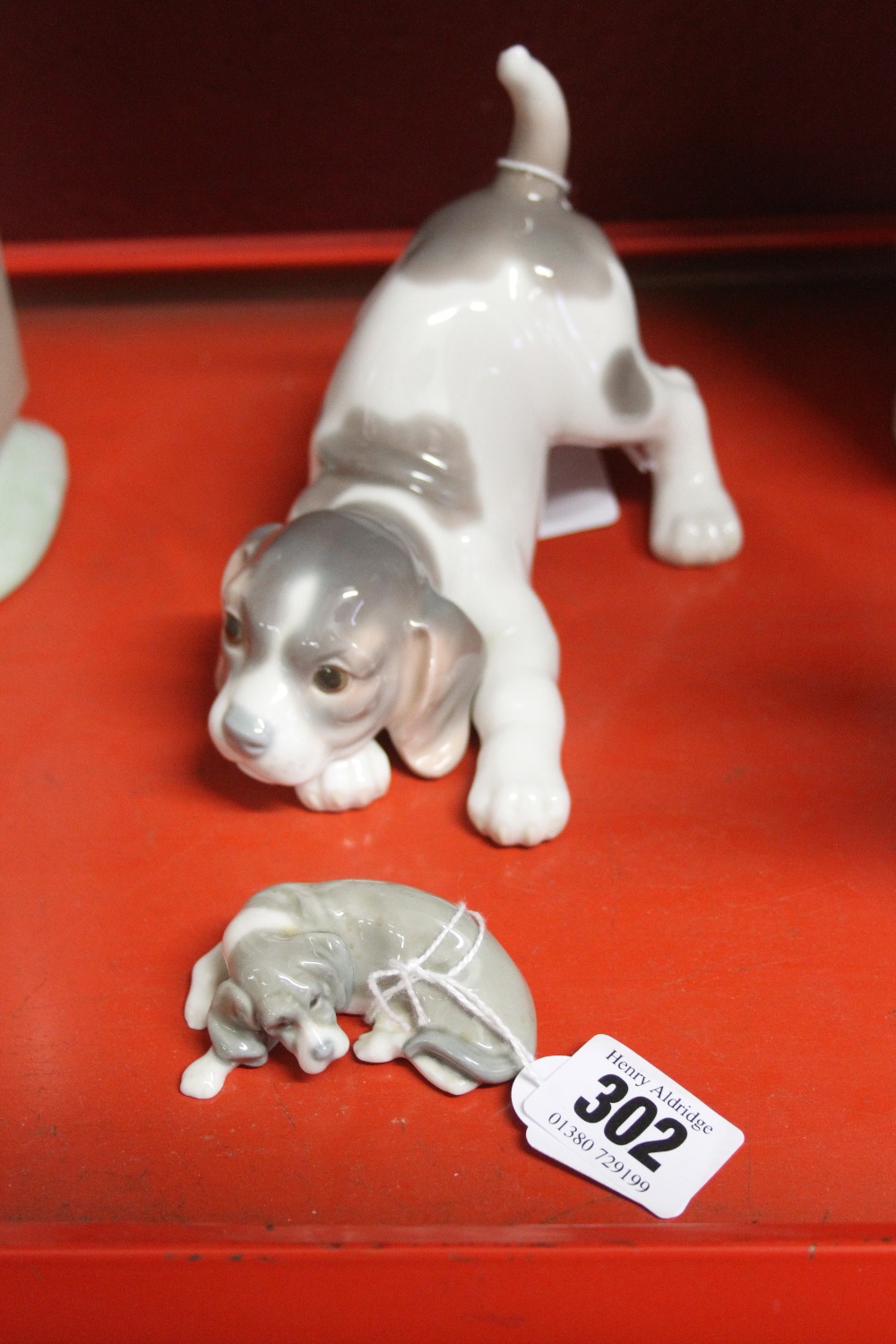20th cent. Ceramics: Lladro playful puppy plus a sleeping dog. (2)