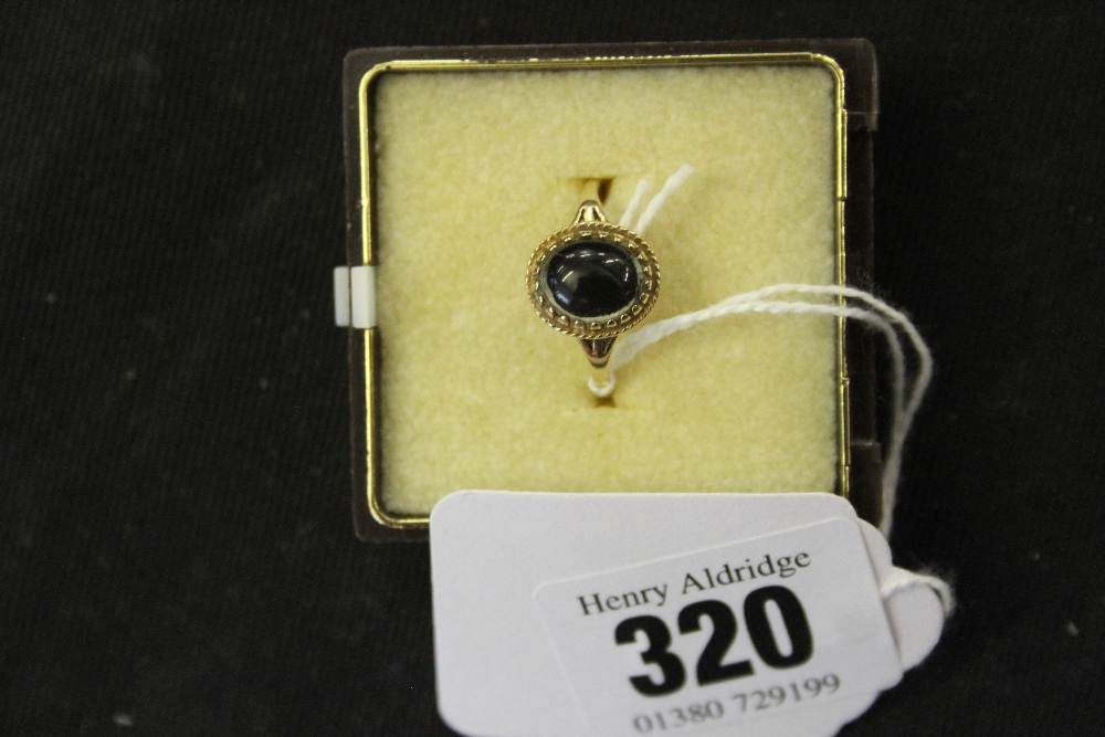 Jewellery: Yellow metal black onyx cabouchon ring, tests 9ct. 1.6g inclusive.