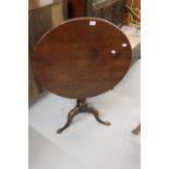 Late George III provincial mahogany tripod table, c1815, the circular top on a baluster turned