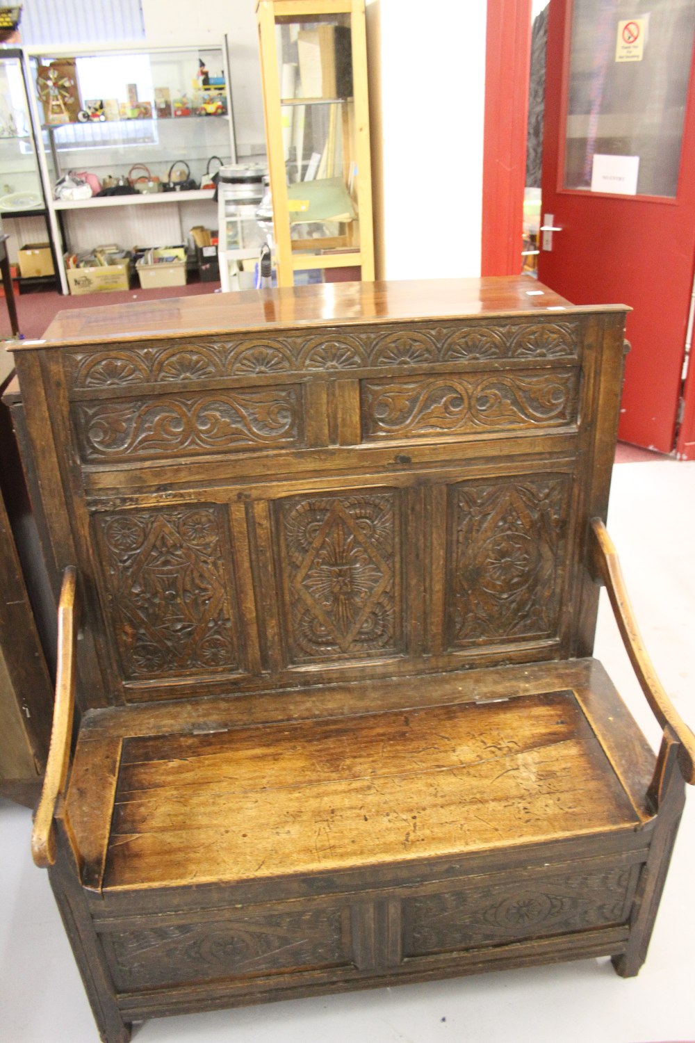 Edwardian settle carved back and front panels with storage compartment 40½ins. x 54½ins. 20ins.
