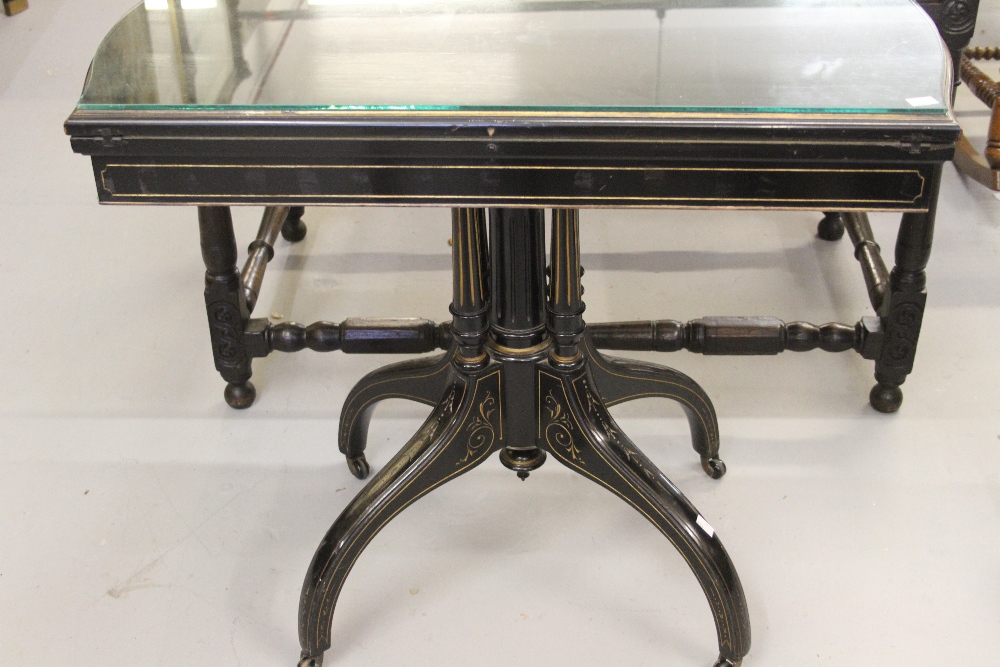 Late Victorian ebonised card table, circa 1880, the hinged shaped rectangular top with a moulded