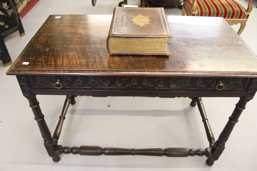 18th cent. Oak side table on turned gun barrel supports. Long drawer front & frieze has carved