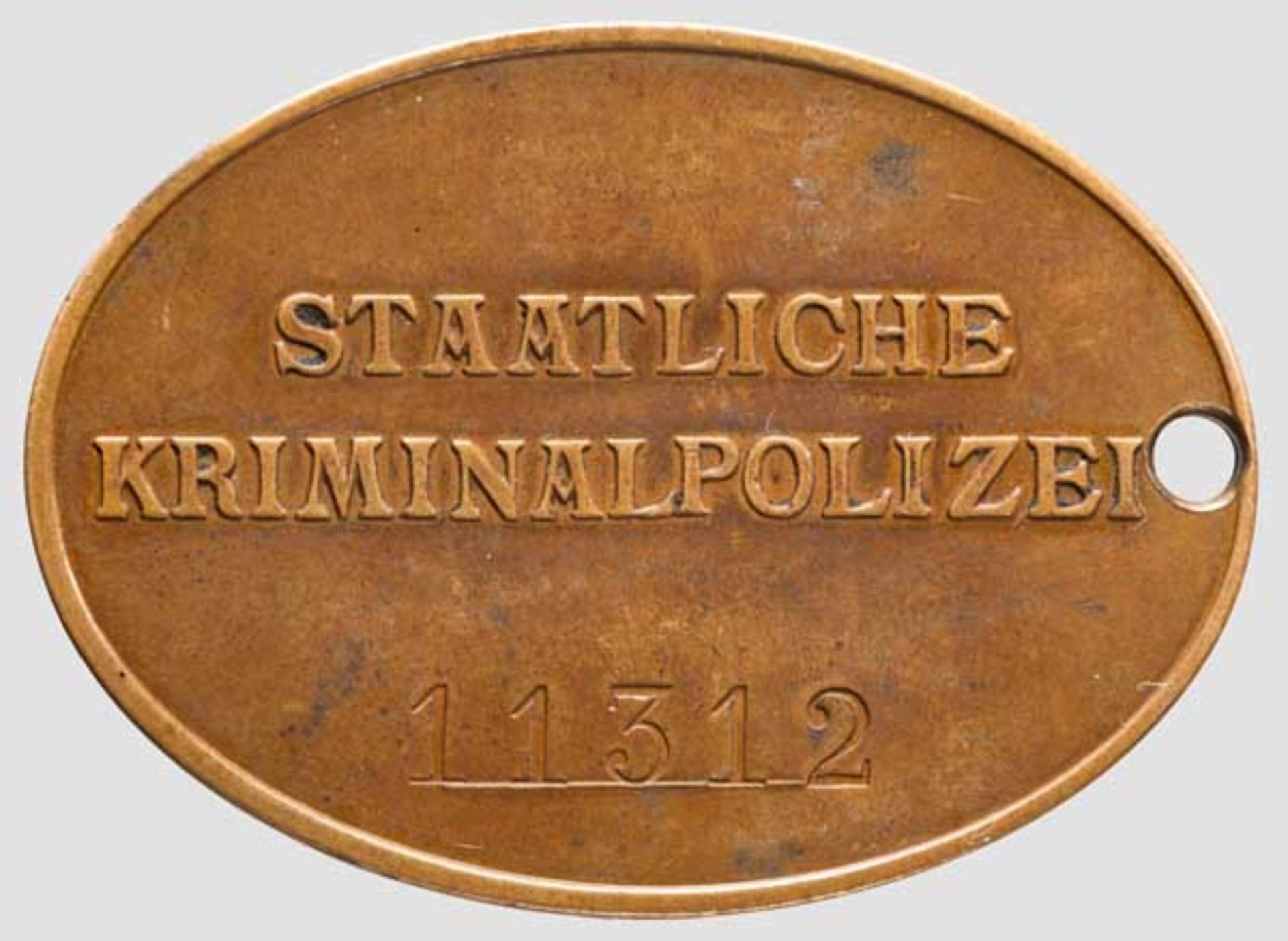 Dienstmarke der staatlichen Kriminalpolizei Bronze mit vorderseitig geprägtem Hoheitsadler. Auf