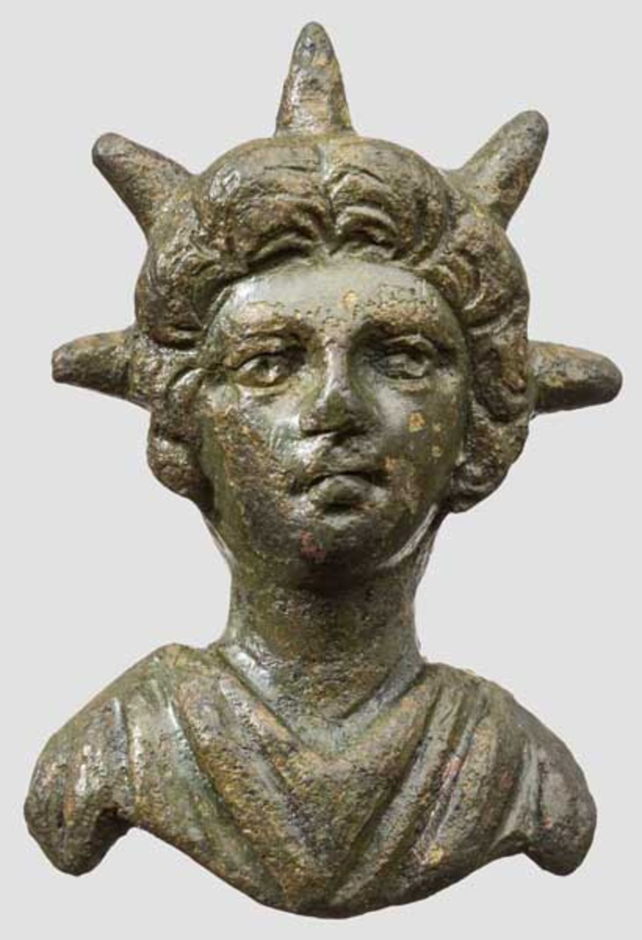 Bronzene Applik mit Büste des Gottes Helios, römisch, 2. - 3. Jhdt. Oberkörper von Gewand mit V-