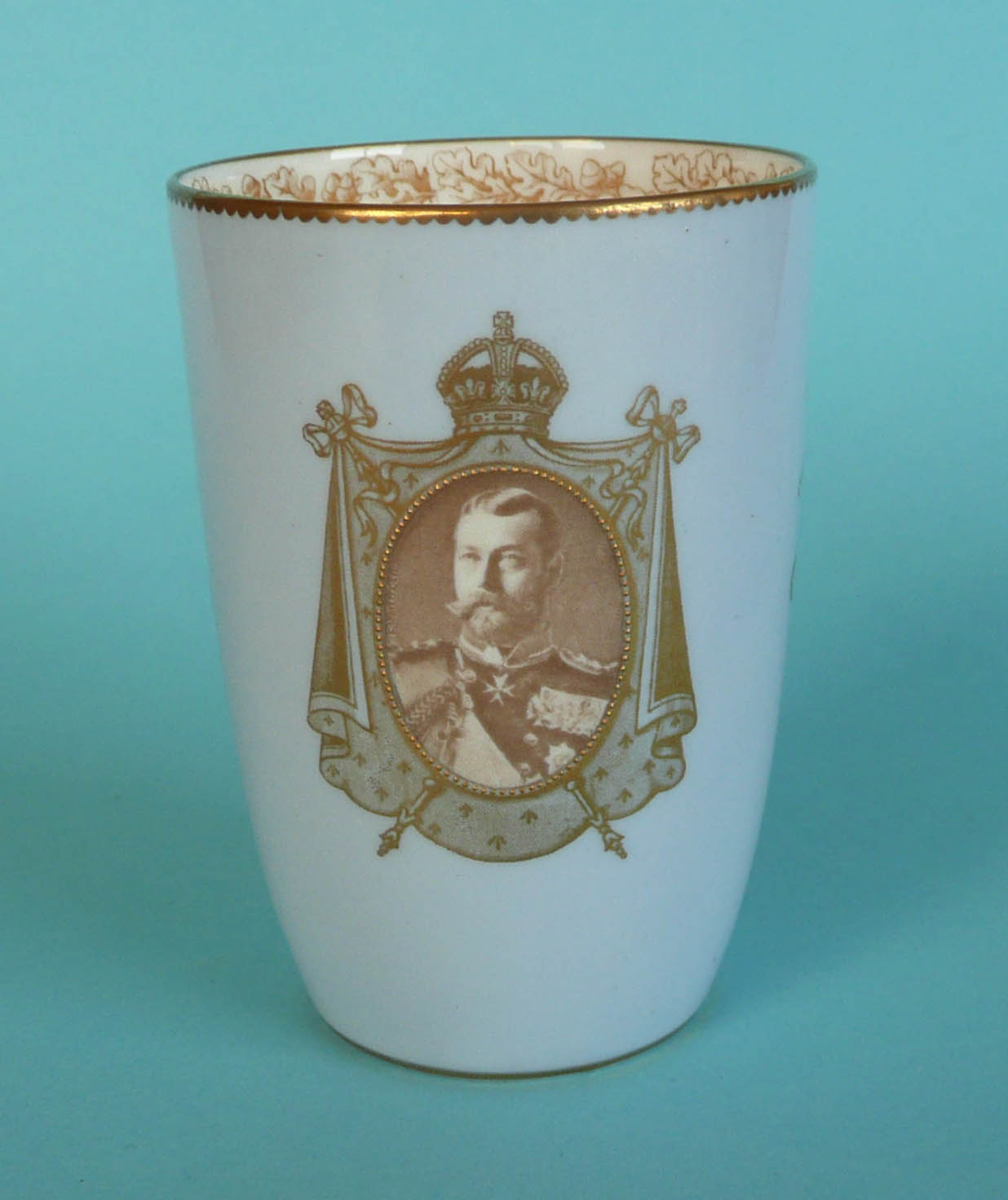 1911 Coronation: a small pale blue ground curved sided beaker by Royal Doulton (commemorative,