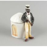 Figürliche Vorratsdose, 20. Jh., elegant gekleideter Mann vor einer Hütte stehend, farbig gefaßt, H.
