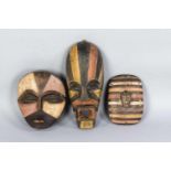 Zwei afrikanische Masken und ein Schild mit Maske, 3. V. 20. Jh., Holz, geschnitzt, farbig