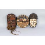 Drei Masken, Elfenbeinküste, 3. V. 20. Jh., Holz, geschnitzt, farbig gefasst, Kokosfasern,