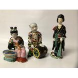 THREE KUTANI FIGURES - A MAN WITH A DRUM, A WOMAN WITH A CAT AND A WOMAN SEATED ON A FISH BOWL,