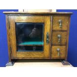 EDWARDIAN OAK SMOKER'S CABINET WITH GLAZED DOOR AND THREE DRAWERS