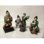 THREE KUTANI FIGURES - A MAN WITH A FISH AND A FAN, A WOMAN WITH A BOWL AND 2 MEN WITH A HAMMER,