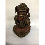 HEAVILY CARVED FOO DOG WITH GILT AND PAINTED DECORATION,