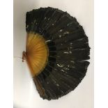 A FRENCH GREEN PEACOCK FEATHER FAN WITH AMBER EFFECT PLASTIC SPINES. 27.