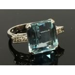 AN AQUAMARINE RING SET WITH DIAMOND SHOULDERS