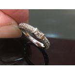 A BEAUTIFUL 18CT WHITE GOLD AND DIAMOND ENCRUSTED HALF ETERNITY RING WITH CENTRAL BAGUETTE CUT