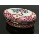 A OVAL PORCELAIN AND SILVER BOX DECORATED WITH FLOWERS.