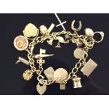 9CT GOLD CHARM BRACELET WITH PADLOCK CLASP WITH APPROX 24 CHARMS