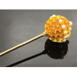 A 9CT GOLD HAT PIN WITH GOLD BALL TO TOP.