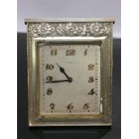 A SWISS WHITE METAL SQUARE DESK CLOCK IN ART DECO STYLE, FLORAL DECORATION TO TOP BORDER.