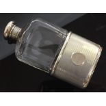 A SILVER AND GLASS HIP FLASK WITH MACHINED FINISH, MONOGRAMMED CARTOUCHE FRONT AND TOP,