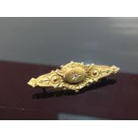 15CT GOLD VICTORIAN BAR BROOCH SET WITH A CENTRAL DIAMOND.