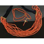 2 CORAL BEAD NECKLACES - A 9 STRING WITH GOLD CLASPS AND VELVET RIBBON THE OTHER WITH CROSS PENDANT